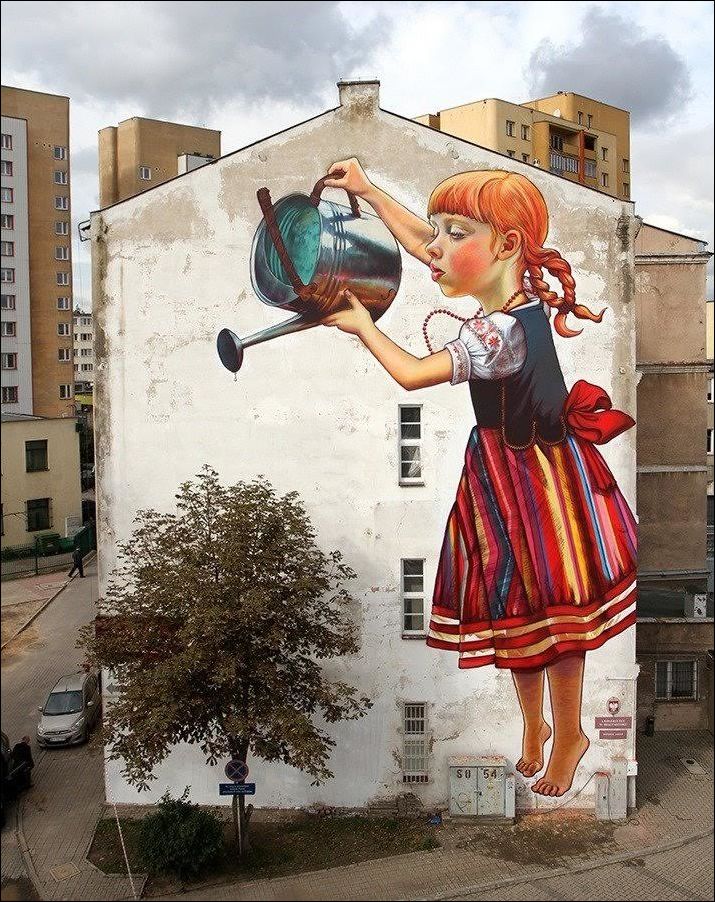 Картина на доме. Девочка поливает дерево.